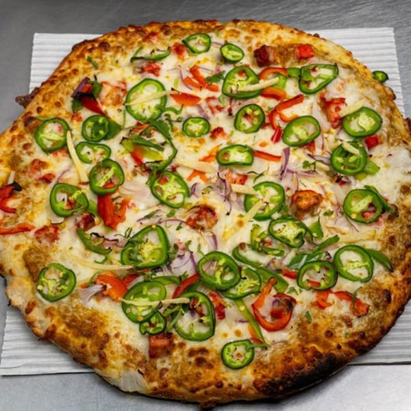 Moon Pizza's spicy pizza with melted cheese, red onions, red peppers, and sliced green jalapeños.