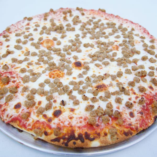 Moon Pizza's sausage pizza, generously topped with crumbled sausage and melted cheese on a red sauce base.