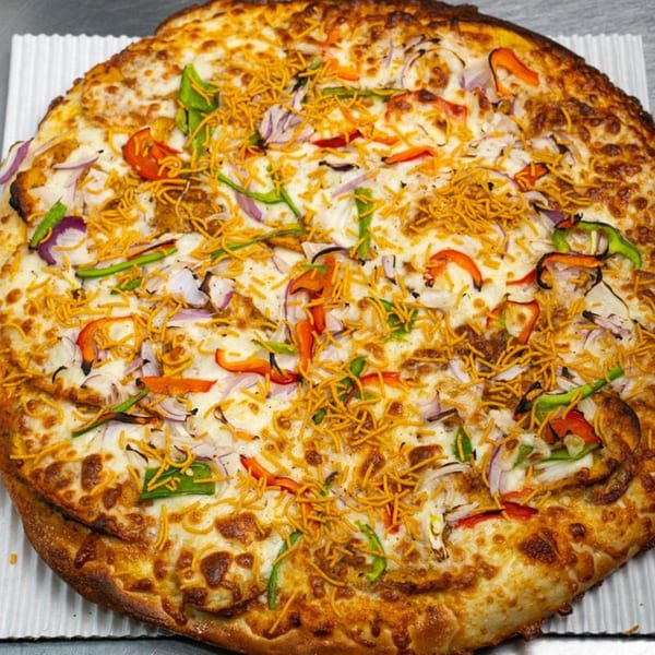 Moon Pizza's pizza topped with white cheese, red onions, green and red peppers, and crispy noodles.
